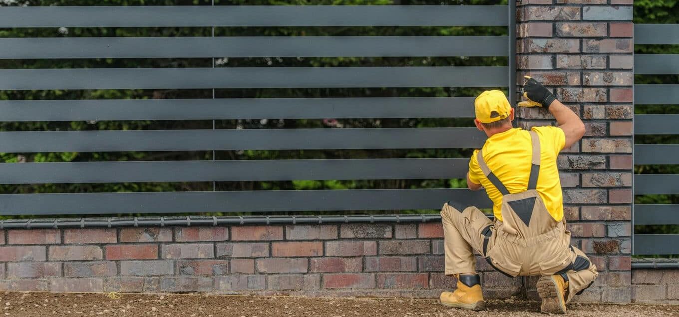 technik montuje ogrodzenie